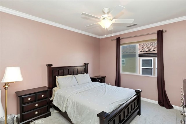 carpeted bedroom with ornamental molding and ceiling fan