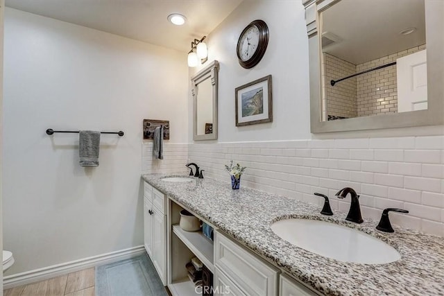 bathroom with vanity, backsplash, and toilet