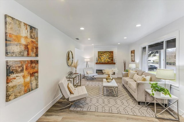 living room featuring a large fireplace and hardwood / wood-style floors