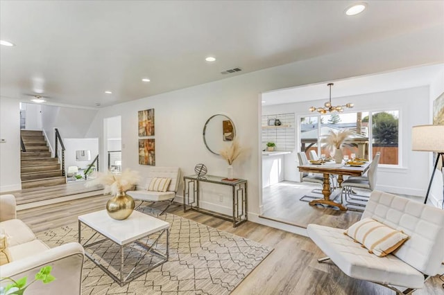 living room with a notable chandelier and light hardwood / wood-style floors