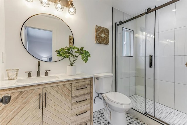 bathroom featuring vanity, a shower with door, and toilet