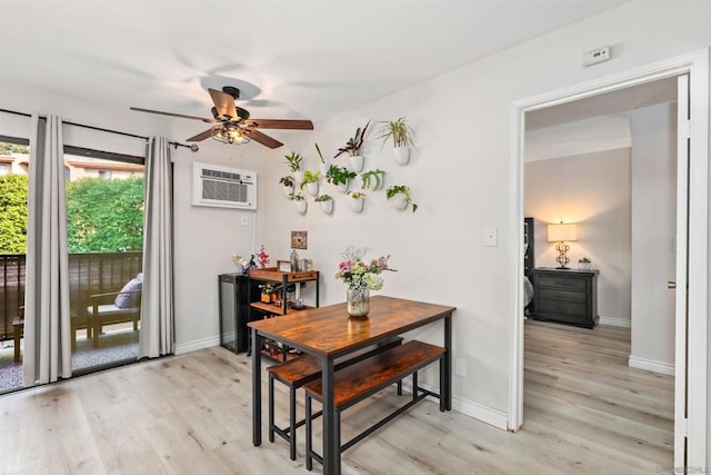 dining space featuring a wall unit AC, light hardwood / wood-style floors, and ceiling fan