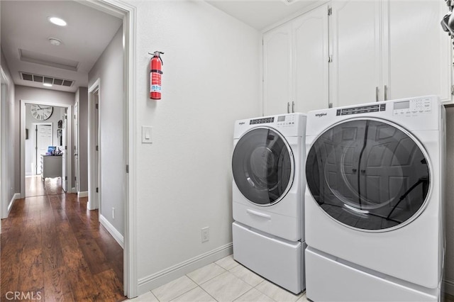 washroom featuring cabinets and washer and clothes dryer