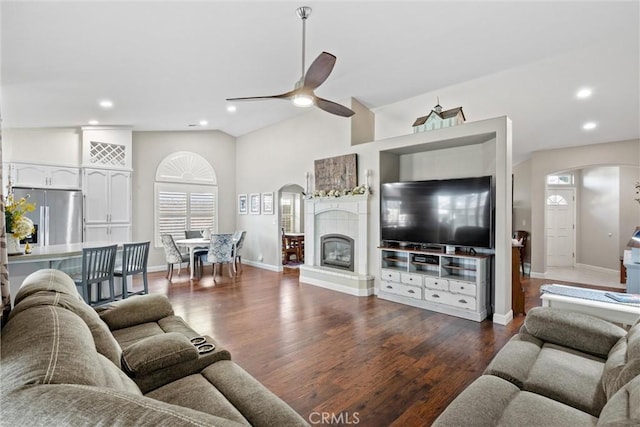 living room featuring ceiling fan, a healthy amount of sunlight, lofted ceiling, and dark hardwood / wood-style flooring