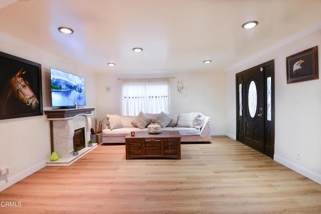 living room with crown molding and light hardwood / wood-style flooring