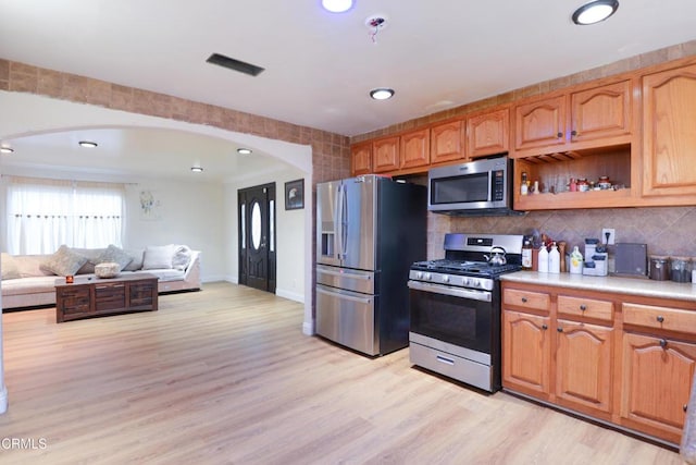 kitchen featuring backsplash, light hardwood / wood-style floors, and appliances with stainless steel finishes