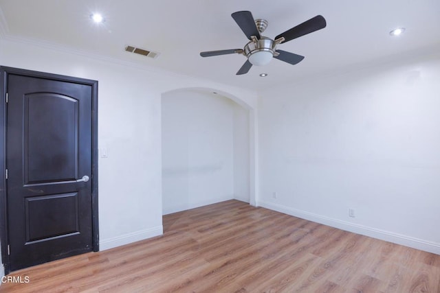 empty room with crown molding, light hardwood / wood-style floors, and ceiling fan