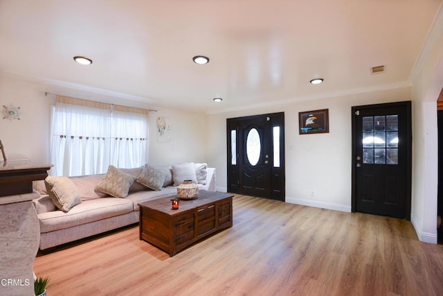 living room featuring ornamental molding and light hardwood / wood-style floors