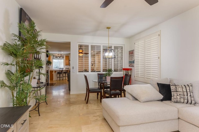 living room with ceiling fan with notable chandelier