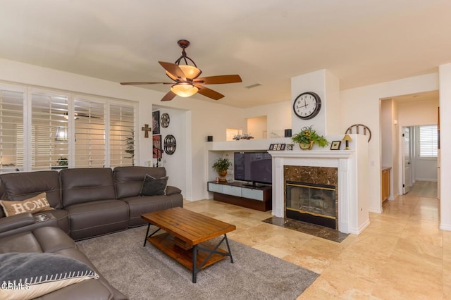 living room with a fireplace and ceiling fan