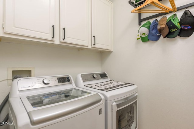 laundry room with separate washer and dryer and cabinets