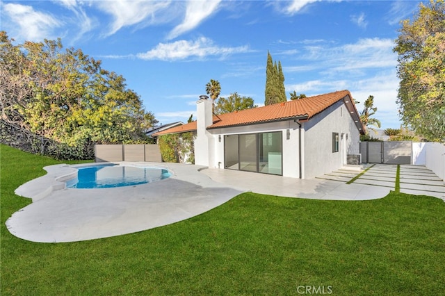 back of house with a fenced in pool, a yard, and a patio