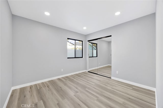 unfurnished bedroom featuring light hardwood / wood-style floors and a closet