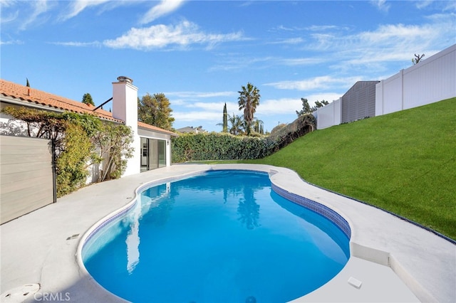 view of swimming pool with a yard