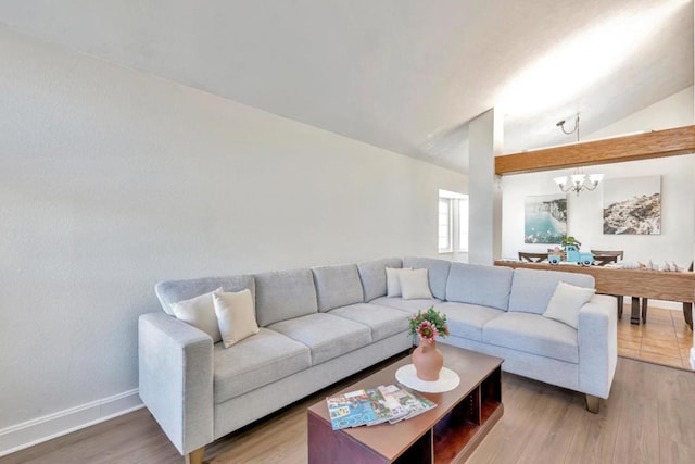 living room with vaulted ceiling, wood-type flooring, and a notable chandelier