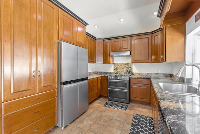 kitchen with light tile patterned flooring, appliances with stainless steel finishes, sink, and dark stone countertops