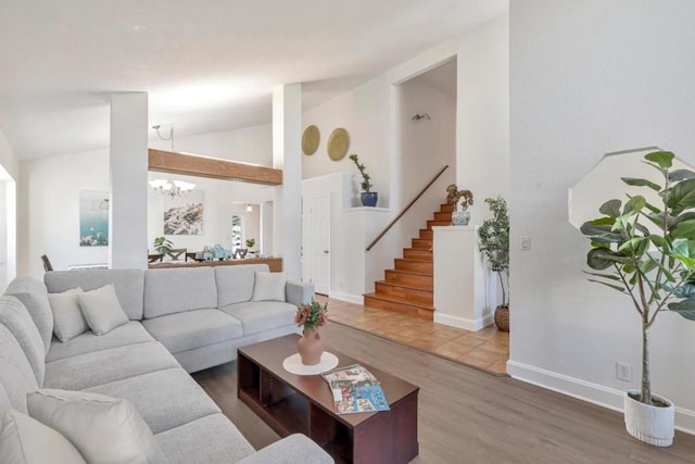 living room with hardwood / wood-style flooring, high vaulted ceiling, and a chandelier