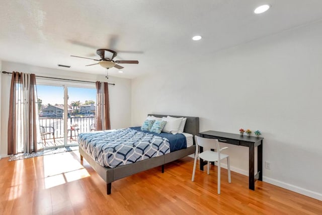 bedroom featuring a water view, access to exterior, ceiling fan, and light hardwood / wood-style flooring