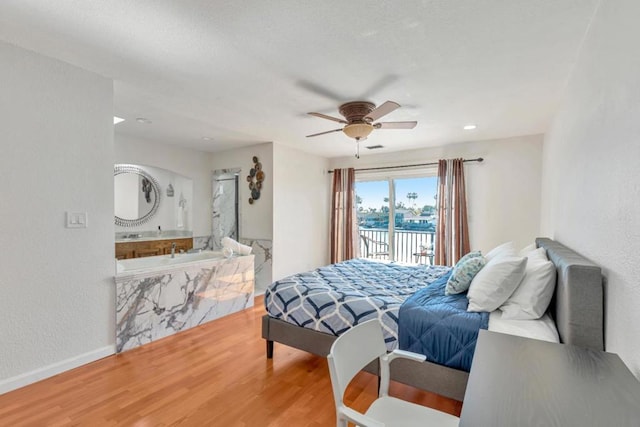 bedroom with connected bathroom, access to outside, hardwood / wood-style floors, and ceiling fan