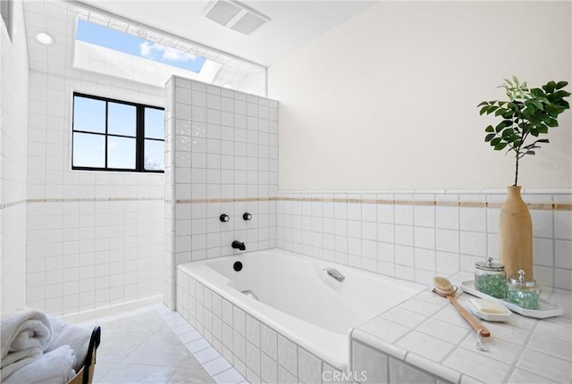 bathroom featuring tile patterned floors and tiled tub