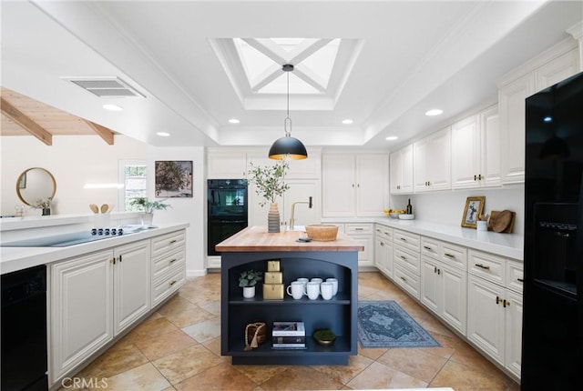 kitchen with pendant lighting, butcher block countertops, a tray ceiling, black appliances, and white cabinets