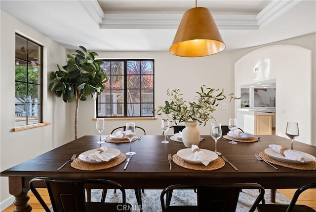 dining area with a tray ceiling and ornamental molding