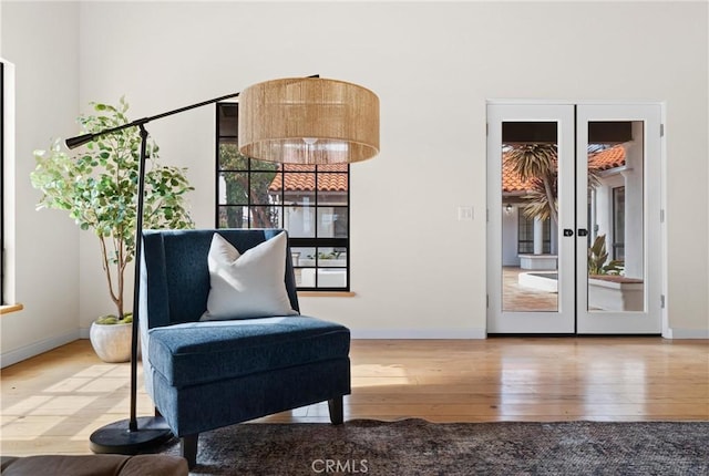 sitting room featuring wood-type flooring and french doors