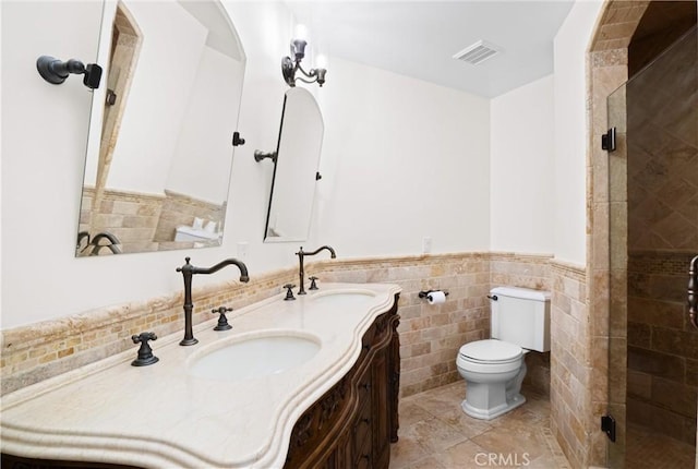 bathroom with tile walls, vanity, walk in shower, toilet, and tile patterned floors