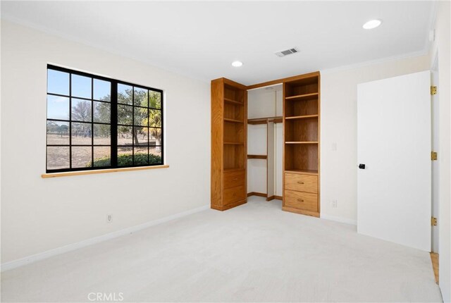 unfurnished bedroom featuring light colored carpet and a closet