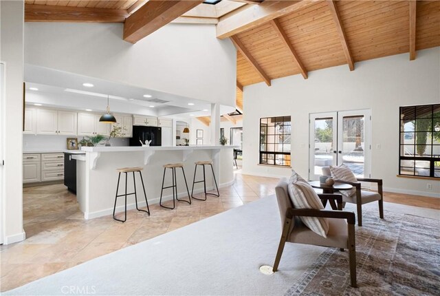 kitchen with decorative light fixtures, white cabinetry, a breakfast bar area, black fridge, and french doors