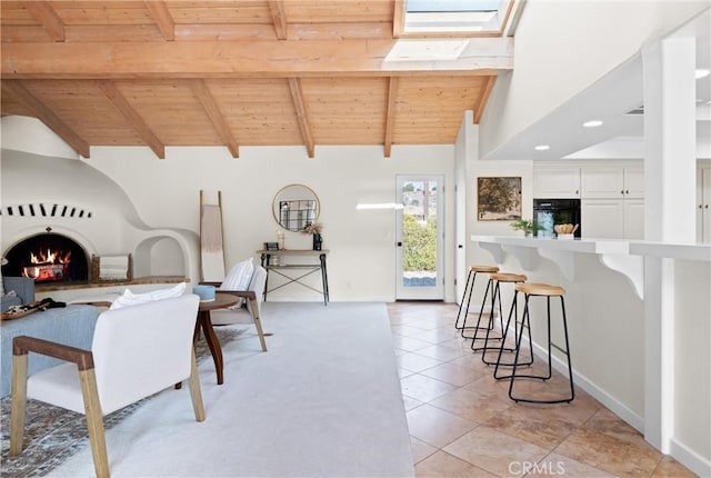 dining area featuring light tile patterned floors, lofted ceiling with beams, and wooden ceiling