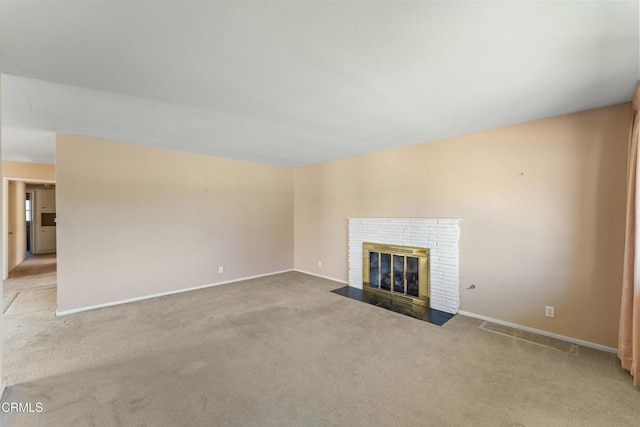 unfurnished living room featuring carpet, a fireplace, and baseboards