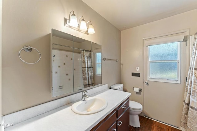 full bath featuring toilet, curtained shower, wood finished floors, and vanity