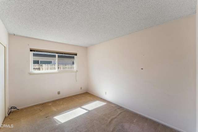 unfurnished room with a textured ceiling and light colored carpet