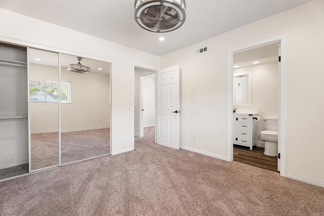 unfurnished bedroom featuring connected bathroom, carpet floors, and a closet