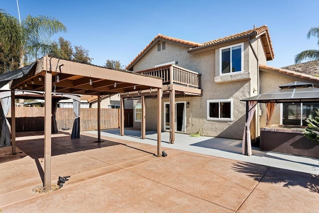 rear view of house with a gazebo, a balcony, and a patio