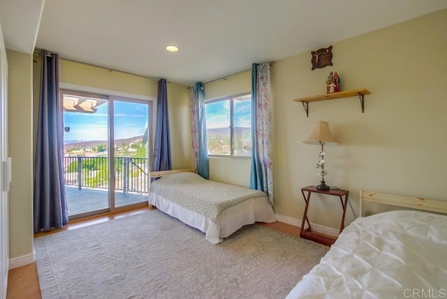 bedroom with wood-type flooring and access to outside