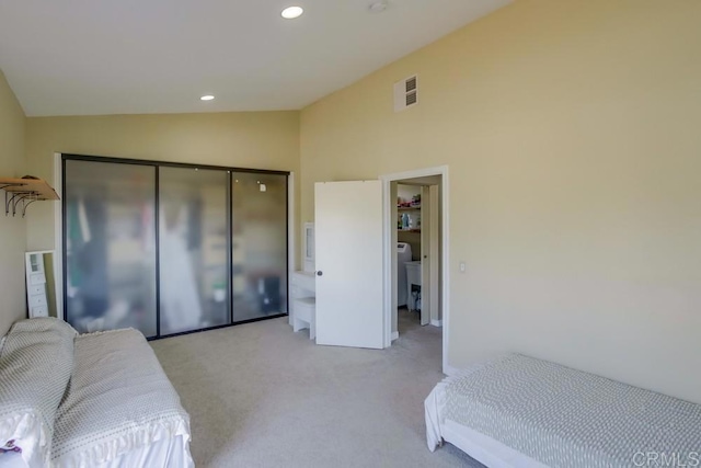 carpeted bedroom featuring lofted ceiling and a closet