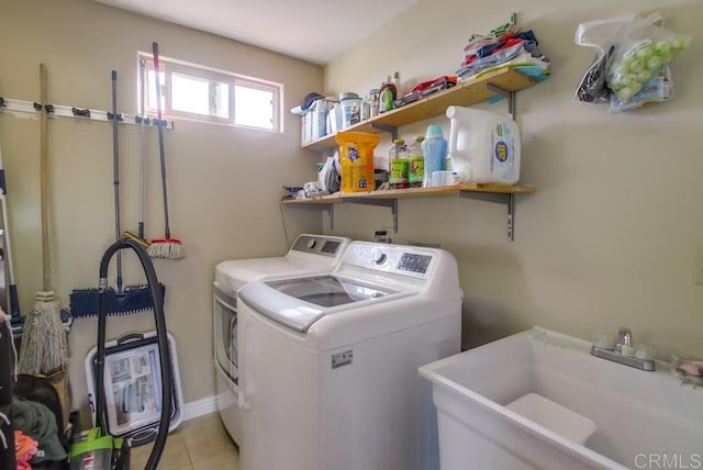 washroom with sink, light tile patterned floors, and washer and clothes dryer