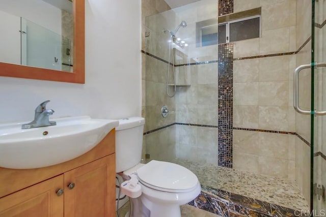 full bathroom with a stall shower, vanity, and toilet