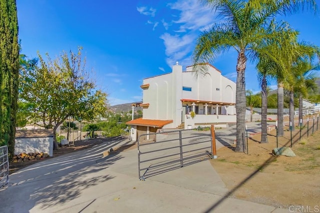 view of front of home with fence, a gate, and stucco siding