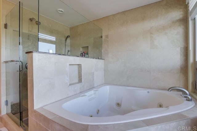 bathroom featuring tile walls, a shower stall, and a whirlpool tub