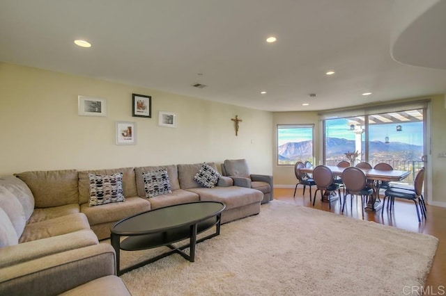 living area featuring baseboards, wood finished floors, and recessed lighting