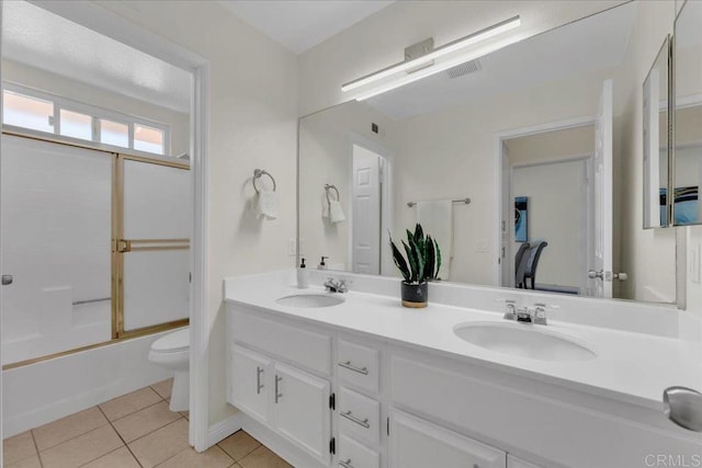 full bathroom featuring enclosed tub / shower combo, tile patterned floors, toilet, and vanity