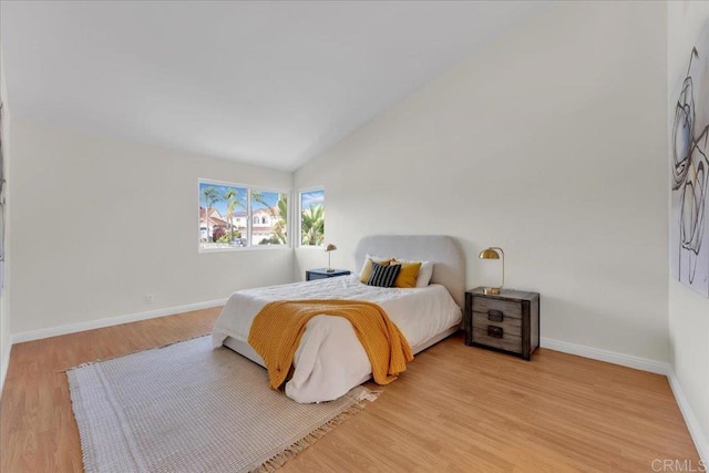 bedroom with light hardwood / wood-style floors and vaulted ceiling