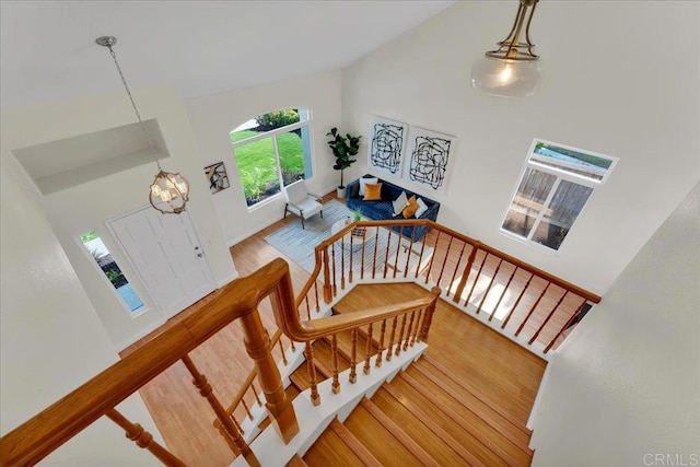 stairs with wood-type flooring and lofted ceiling