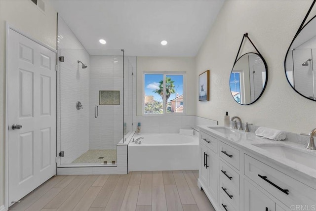 bathroom featuring vanity and shower with separate bathtub