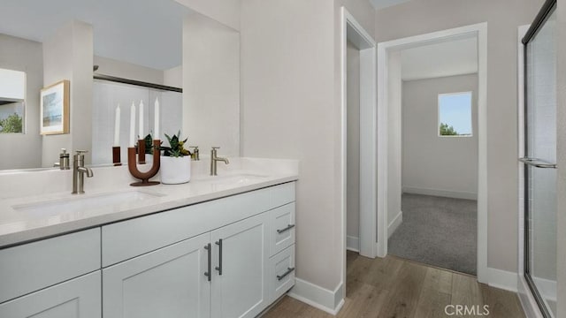 bathroom with vanity, hardwood / wood-style floors, and a shower with door