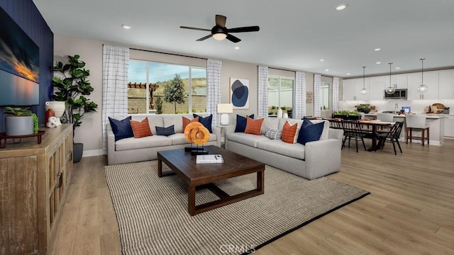 living room featuring light hardwood / wood-style floors and ceiling fan