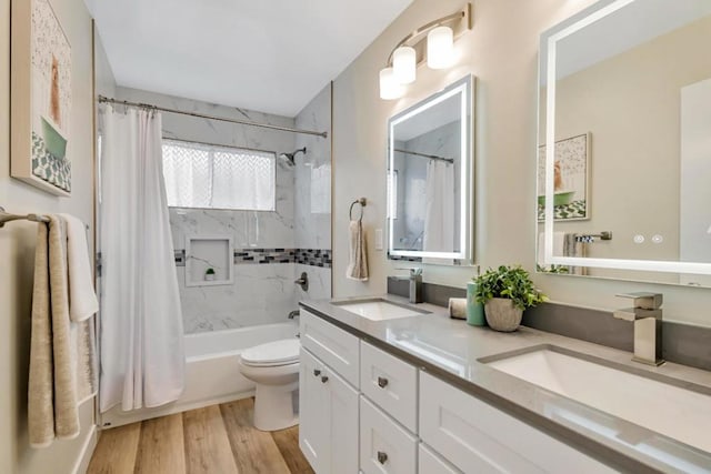 full bathroom featuring vanity, hardwood / wood-style floors, toilet, and shower / bath combo